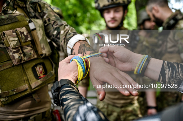 ZAPORIZHZHIA REGION, UKRAINE - MAY 28, 2023 - A serviceman of the 128th Mountain Assault Brigade gets a patriotic bracelet during the 30th C...
