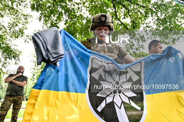 ZAPORIZHZHIA REGION, UKRAINE - MAY 28, 2023 - A serviceman of the 128th Mountain Assault Brigade holds a flag, Zaporizhzhia Region, southeas...