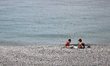 People sit on a beach in Nice, France on May 29, 2023. 