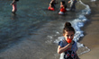 Palestinians enjoy swimming in the Mediterranean sea on the coast of Gaza City, on May 31,...