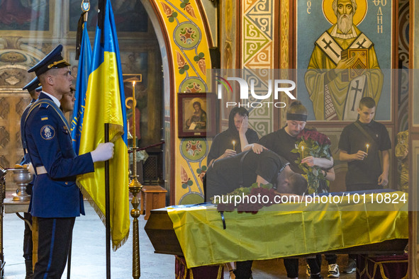 Relatives of Mikola Vasiliovich lie on his coffin during a holy mass in Saint Michael's Golden Domed Cathedral. Mikola was a ukrainian soldi...