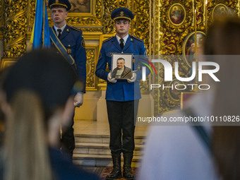 A scort soldier holds the photo of Mikola Vasiliovich during a holy mass in Saint Michael's Golden Domed Cathedral. Mikola was a ukrainian s...