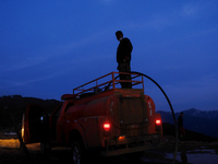 MULI, CHINA - JUNE 1, 2023 - Local villagers fill a light tanker with water as they continue to deliver water for fire and rescue workers to...