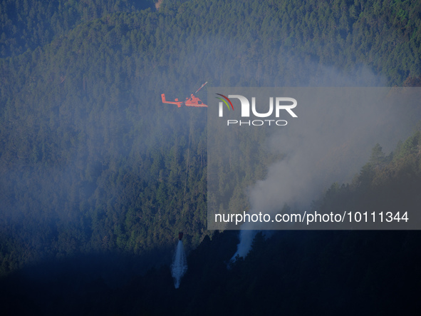 MULI, CHINA - MAY 31, 2023 - A helicopter drops water on a fire site in Muli county, Liangshan, Sichuan province, China, May 31, 2023. At 11...