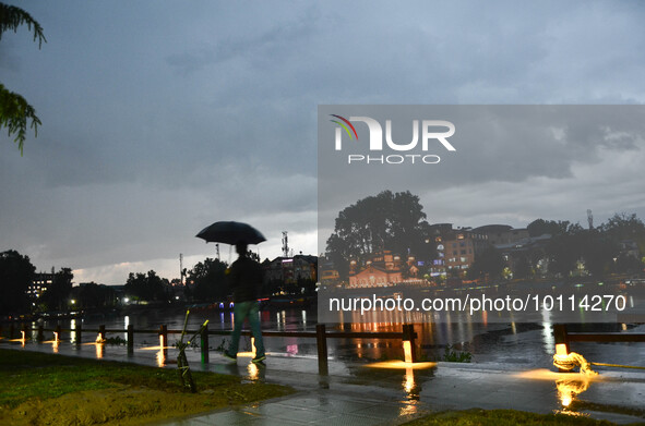 A man walks with an umbrella during a thunderstorm  in city center Lal Chowk , Srinagar, Indian Administered Kashmir on 02 June 2023.  
