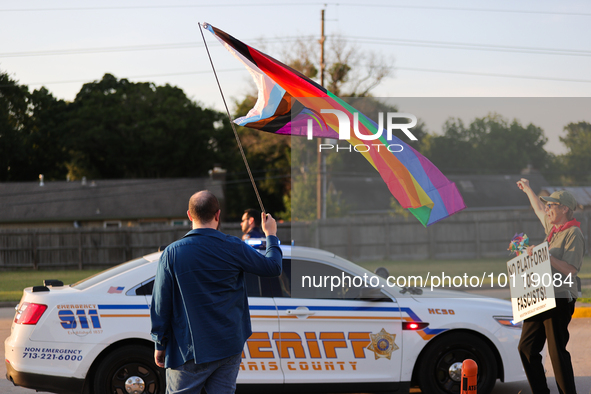 A pro-LGBTQ protestor holds a gay/transgender pride flag outside First Christian Church in Katy, Texas on June 3, 2023. 