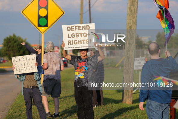 A pro-LGBTQ protestor holds a sign that reads, ''defend LGBTQ+ rights!'' Outside First Christian Church in Katy, Texas on June 3, 2023. 