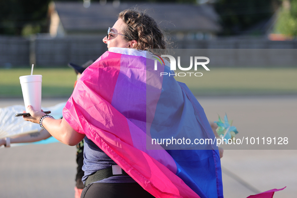 A pro-LGBTQ protestors hold signs and wear LGBTQ pride flags in support of First Christian Church's Trans Youth program in Katy, Texas on Ju...