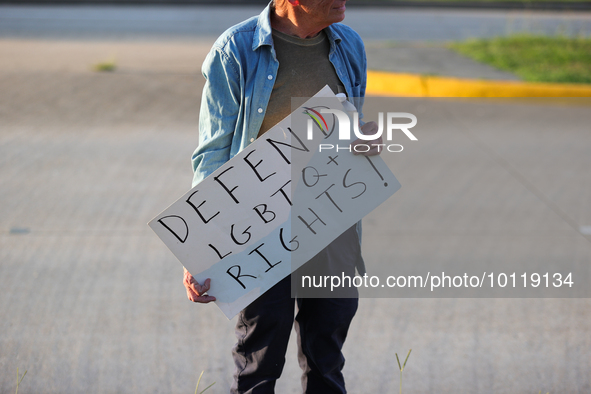 A pro-LGBTQ protestor holds a sign that reads, ''defend LGBTQ+ rights!'' Outside First Christian Church in Katy, Texas on June 3, 2023. 