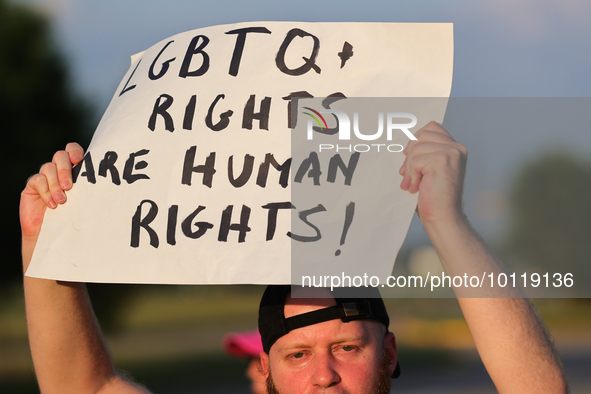 A pro-LGBTQ protestor holds a sign that reads, ''LGBTQ+ rights are human rights!'' Outside First Christian Church in Katy, Texas on June 3,...