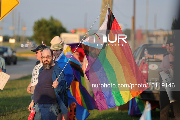 A pro-LGBTQ protestor holds a gay/transgender pride flag outside First Christian Church in Katy, Texas on June 3, 2023. 