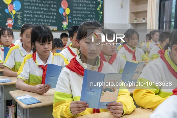 Pupils read publicity materials on fraud prevention, June 19, 2023, Nantong, Jiangsu Province, China. 