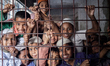 Kids are smiling before the camera. Many orphan children live and study in madrasas. They...