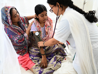 A Doctor treats a patient covered with mosquito nets who are suffering from dengue fever rest inside the 'Shaheed Suhrawardy' Medical Collea...