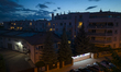 An InPost Paczkomat package locker is seen lit up after sunset in a residential neighbourh...