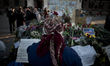 A woman mourns in front of flowers outside the burnt trade union building in Odessa, Ukrai...
