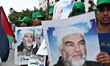 Palestinian Hamas supporters wave national flags while holding pictures of Sheik Raed Sala...