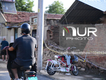 DEZHOU, CHINA - AUGUST 6, 2023 - A citizen passes a collapsed house after an earthquake in an urban area of Pingyuan County, in Dezhou, Shan...