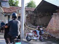 DEZHOU, CHINA - AUGUST 6, 2023 - A citizen passes a collapsed house after an earthquake in an urban area of Pingyuan County, in Dezhou, Shan...