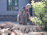 DEZHOU, CHINA - AUGUST 6, 2023 - An elderly man deals with the collapse of a wall at a residential house in an urban area of Pingyuan County...