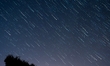 Images depict the paths of stars and the movement of falling meteors through long-exposure...