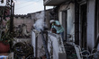 A resident is extinguishing the last flames from his house on Mount Parnitha in Athens, Gr...