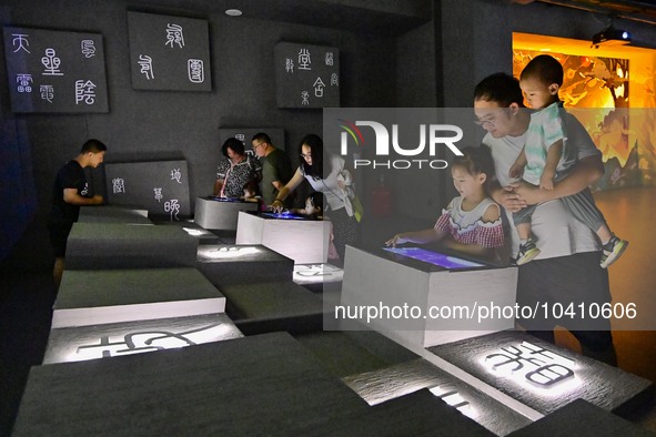 Tourists experience writing ancient Chinese characters at the ''Time and Space Tunnel'' pavilion of Qingzhou Ancient City Scenic spot in Eas...
