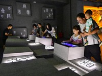 Tourists experience writing ancient Chinese characters at the ''Time and Space Tunnel'' pavilion of Qingzhou Ancient City Scenic spot in Eas...