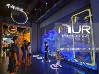 Visitors take part in an interactive game at the ''Time and Space Tunnel'' pavilion of Qingzhou Ancient City Scenic spot in East China's Sha...