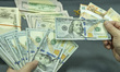 NANTONG,CHINA - SEPTEMBER 1, 2023 - A bank employee counts U.S. dollars in Nantong, Jiangs...