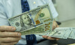 NANTONG,CHINA - SEPTEMBER 1, 2023 - A bank employee counts U.S. dollars in Nantong, Jiangs...