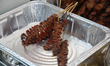 Pork isaw (skewers made with meat from the pigs large intestines) at a food stall during t...