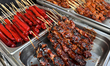 Pork pig ear skewers along with sausages and pork skewers at a food stall during the Taste...