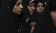 Veiled Iranian women stand at a holy shrine during a religious ceremony to commemorate Arb...