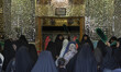 Shi'ite pilgrims stand in front of a tomb at a holy shrine while taking part in a religiou...