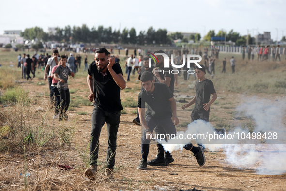A Palestinian protester holds a tear gas canister fired by Israeli forces during a demonstration along the border between the Gaza Strip and... by Majdi Fathi/NurPhoto