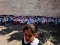 A Palestinian girl walks in front of pictures of Palestinian prisoners, which stages a protest in solidarity with Palestinian prisoners on h...