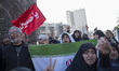 A veiled Iranian protester holds an Iran flag as she shouts anti-U.S. and anti-Israel slog...
