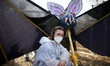 A protester poses in front of a bat in papier-mache. Nearly 10 000 people participated to...