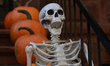 Creepy things with horns and skeletons with pumpkins cover the exterior of a townhouse in...