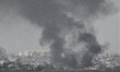 Smoke rises from buildings demolished by Israeli Air Force airstrikes and artilery are see...