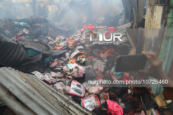 A burnt textile product is being examined in Baburhat, Narsingdi, Bangladesh, on October 30, 2023, following a fire. The location is current...