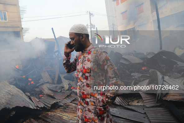 A trader is currently discussing the damaged textile products with his family after inspecting the fire damage in Baburhat, Narsingdi, Bangl...