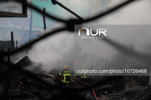 Fire service personnel from Bangladesh are extinguishing a fire in Baburhat, Narsingdi, Bangladesh, on October 30, 2023. This area is known...