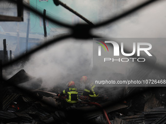 Fire service personnel from Bangladesh are extinguishing a fire in Baburhat, Narsingdi, Bangladesh, on October 30, 2023. This area is known...