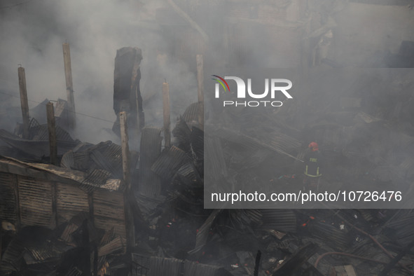 Fire service personnel from Bangladesh are extinguishing a fire at one of the largest textile wholesale markets in Baburhat, Narsingdi, Bang...