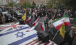 Iranian protesters walk past flags of the U.S., Britain, and Israel during an anti-U.S. an...