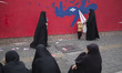 Veiled Iranian women in front of an anti-U.S. mural on a wall of the former U.S. embassy i...