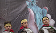 Young Iranian schoolboys in military uniforms standing under an anti-U.S. banner while per...