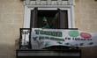 An activist from "La PAH"  with the face covered shouts after occupy a building in La Lati...